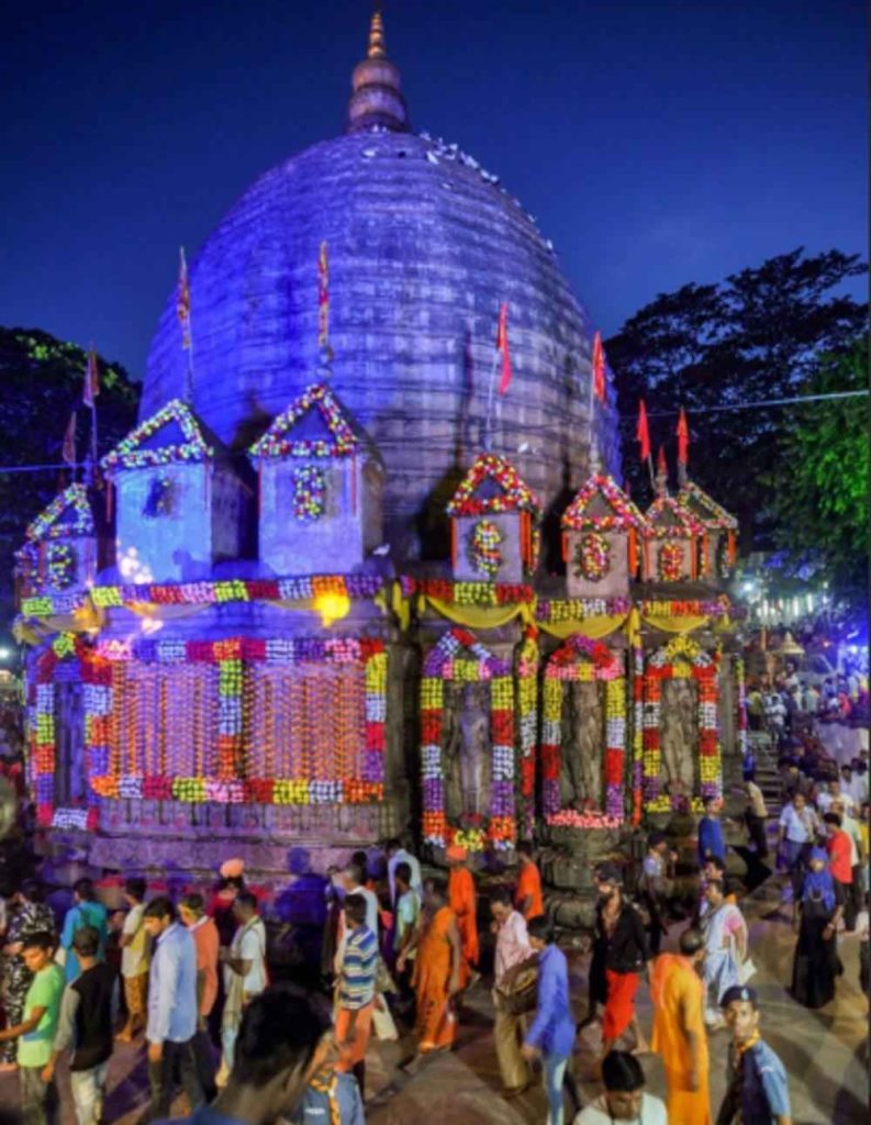 Kamakhya Temple illuminated at night during Ambubachi Mela with devotees gathered in Guwahati