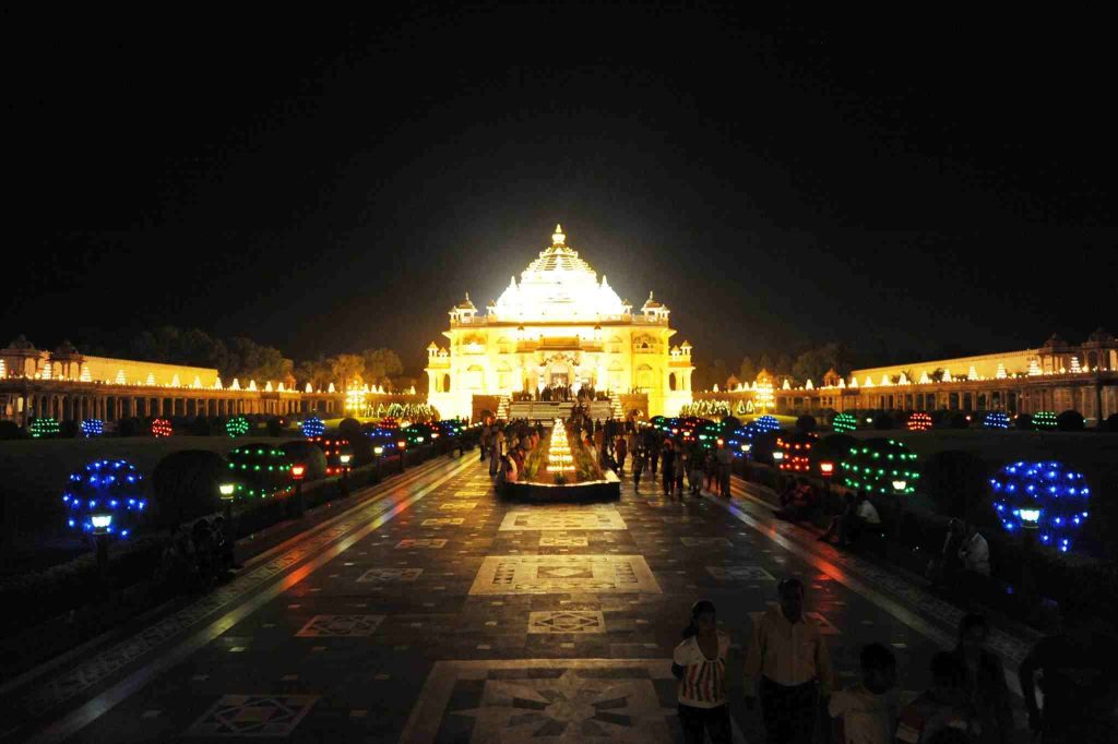 Ambaji Temple Gujarat illuminated at night with colorful lights and devotees visiting the temple