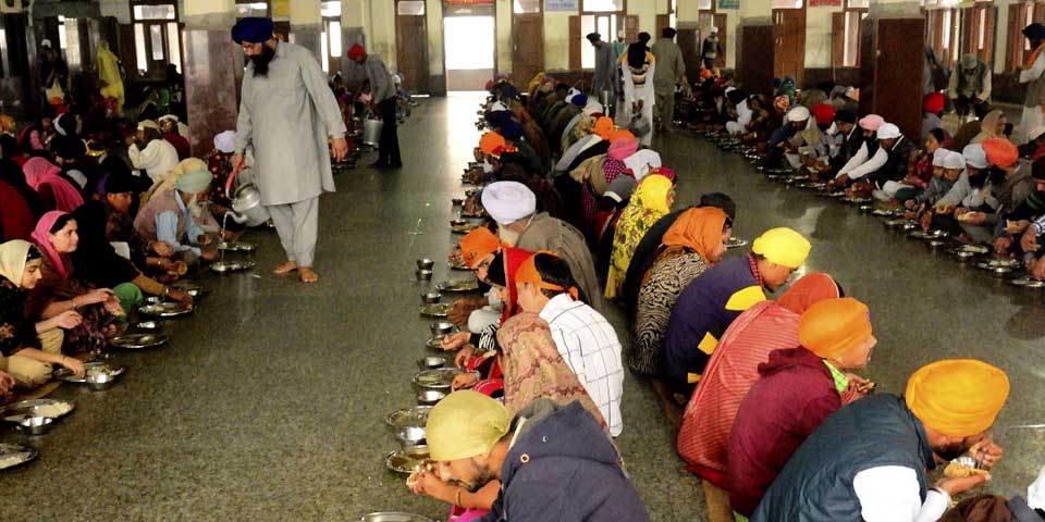 Devotees sitting together for langar at the Golden Temple community kitchen in Amritsar