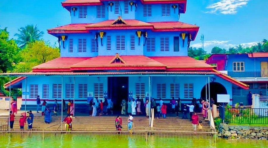 Parassinikadavu Muthappan Temple near the riverside with traditional Kerala temple architecture.