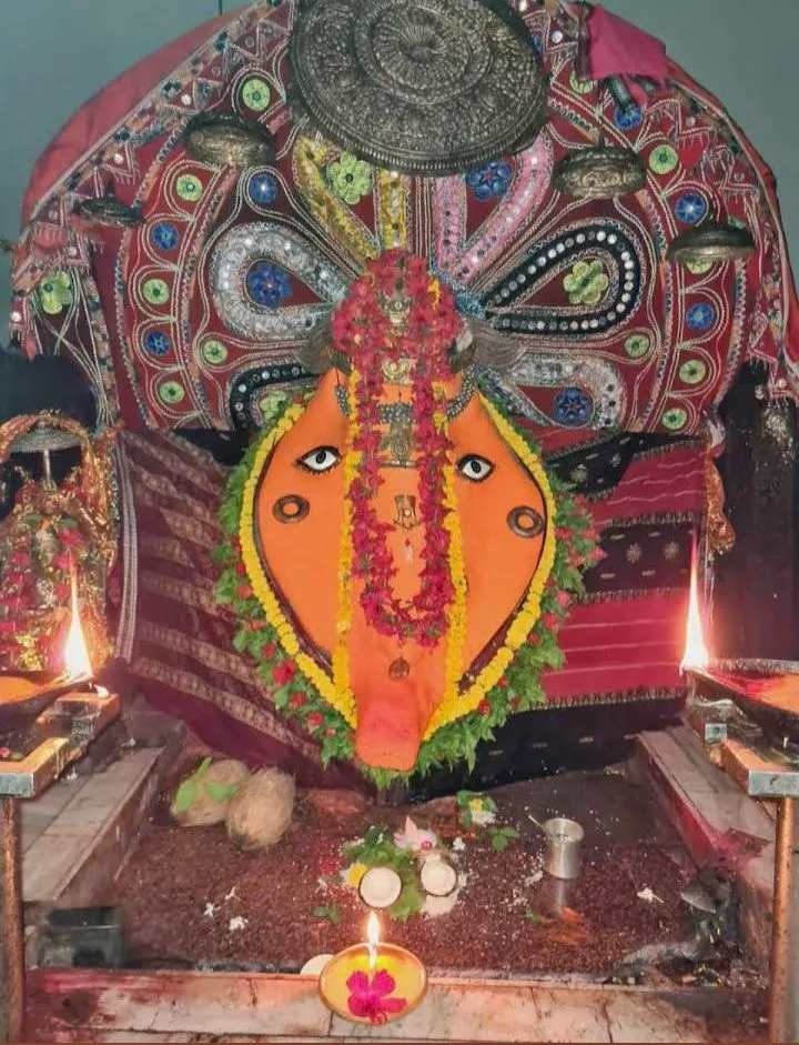 Sacred idol of Maa Samaleswari decorated with traditional ornaments and flowers inside the temple sanctum.