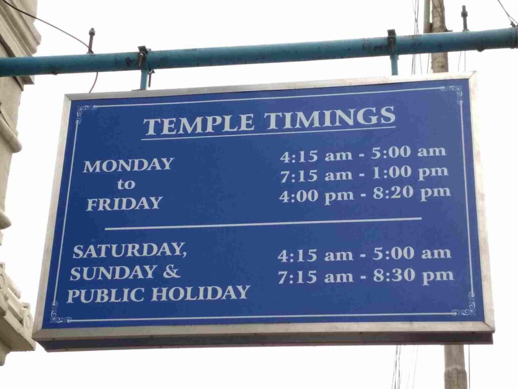 Temple timings board displaying darshan and visiting hours at ISKCON Bangalore temple.